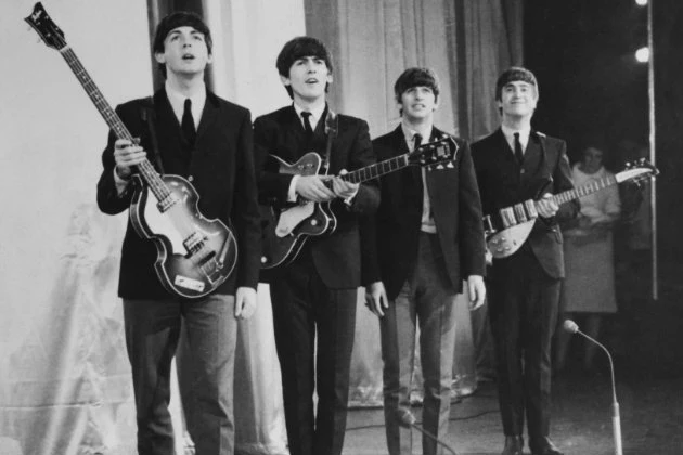 The Beatles take a bow after performing at the Prince of Wales Theater circa 1963.